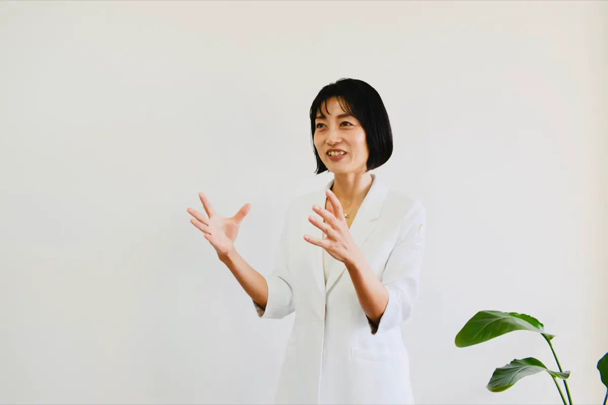 白衣の講師が笑顔で解説する様子